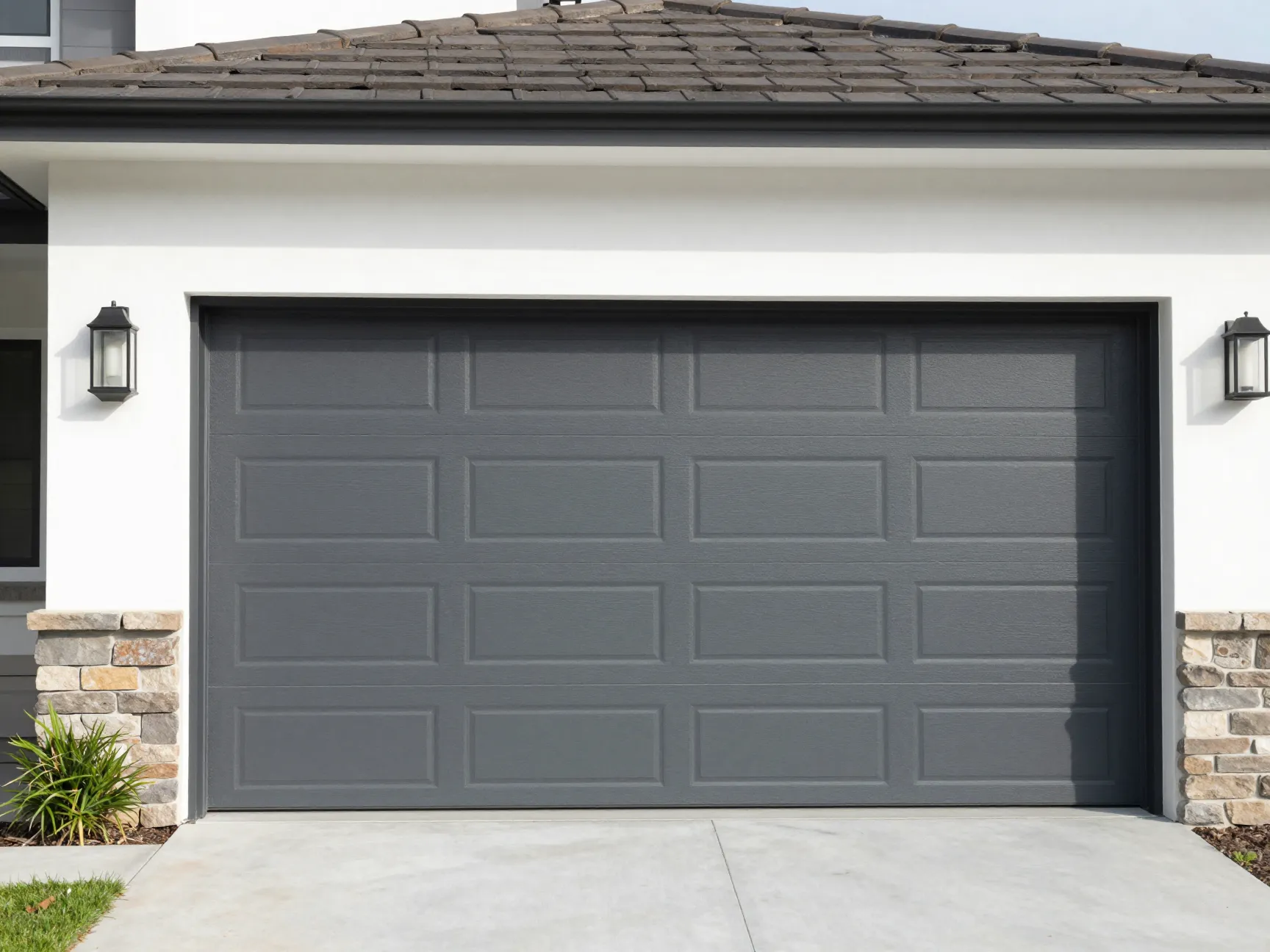 Modern automatic sectional garage door in anthracite color on a clean house facade,